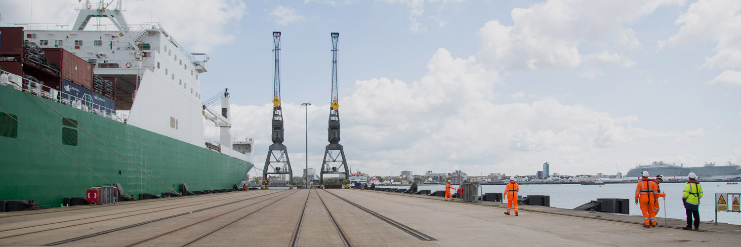 a view across the jetty with two cranes at the end