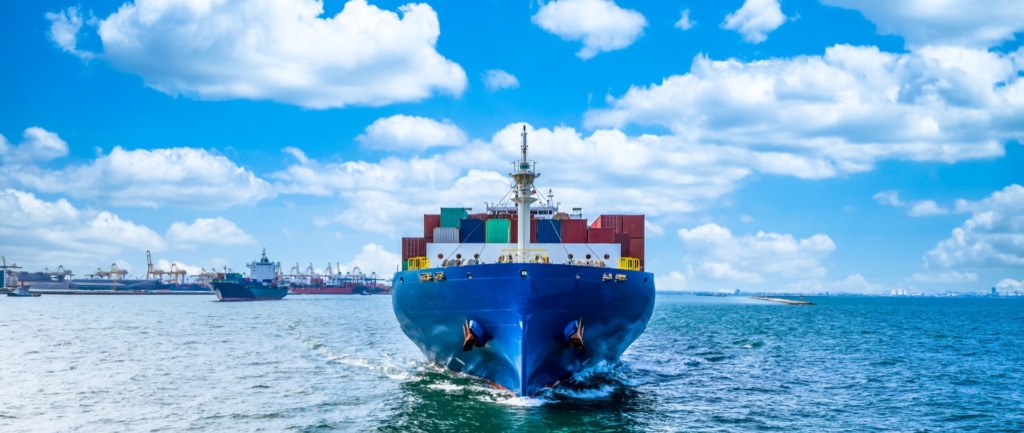 a large blue container ship sailing towards the camera