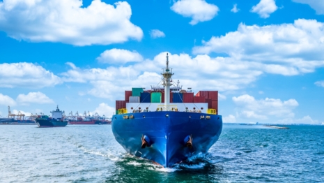 a large blue container ship sailing towards the camera