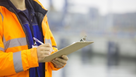 someone in a high vis jacket holding a clipboard