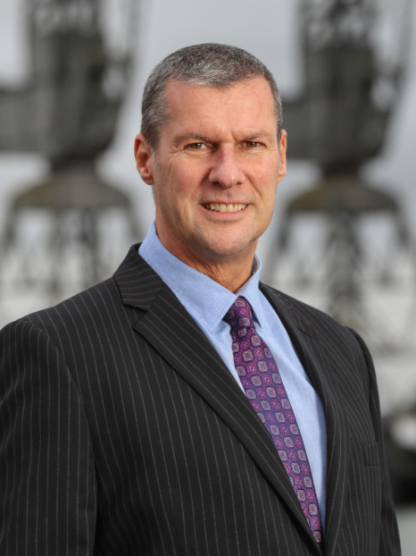 chris symonds in a suit smiling at the camera