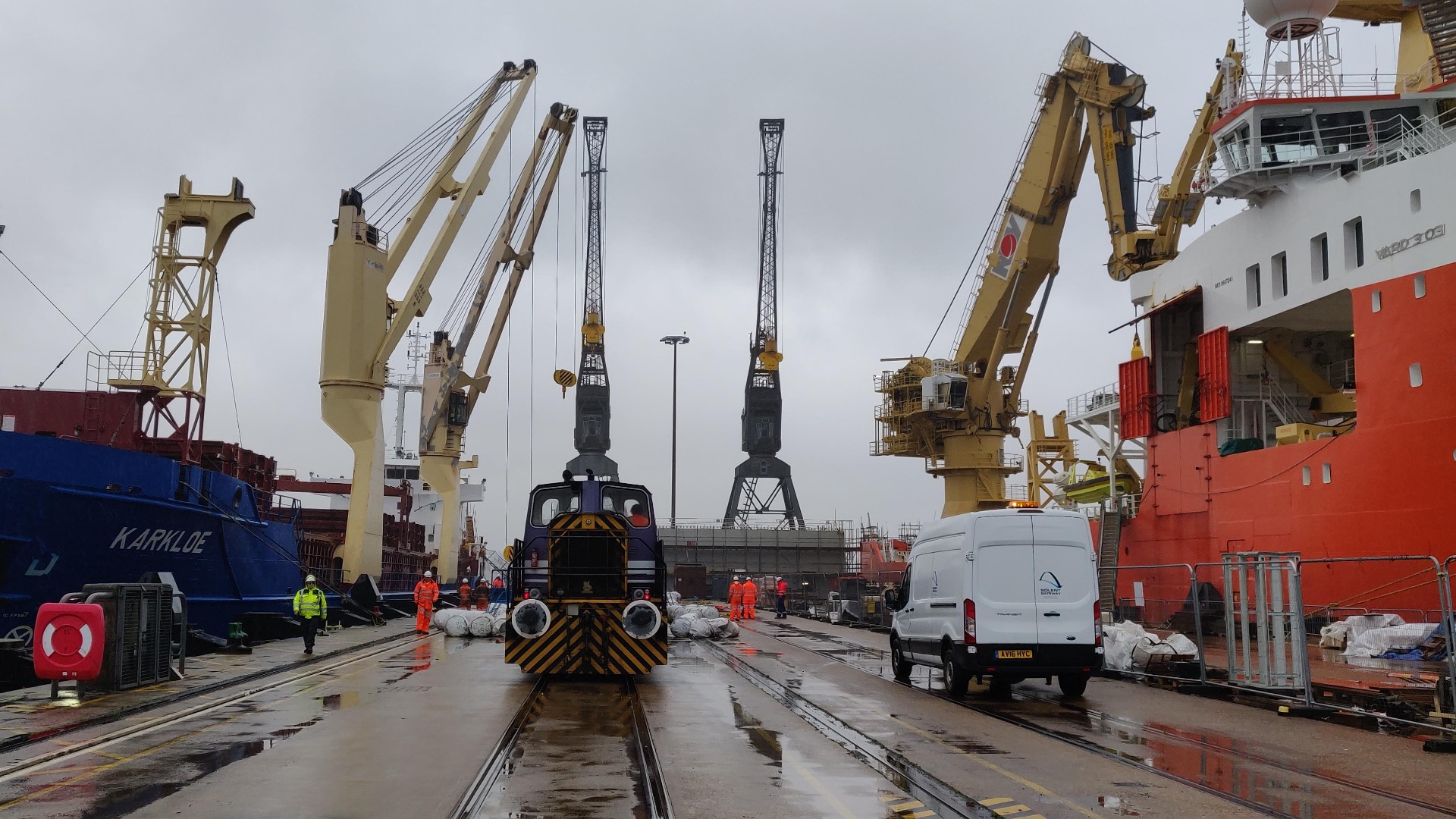 two boats berthed at a dock with cranes surrounding them